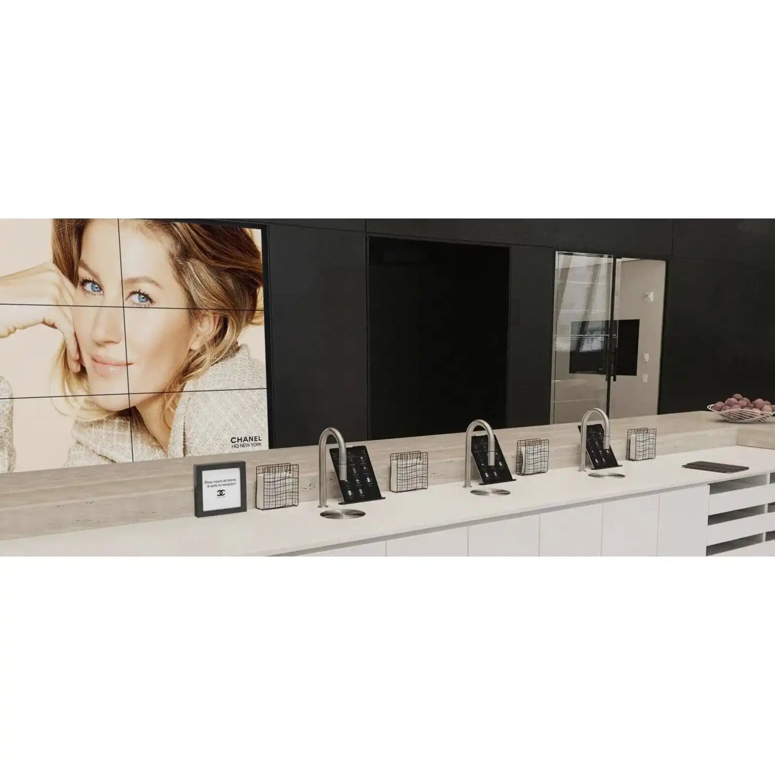A display counter with multiple interactive digital screens and product samples.
