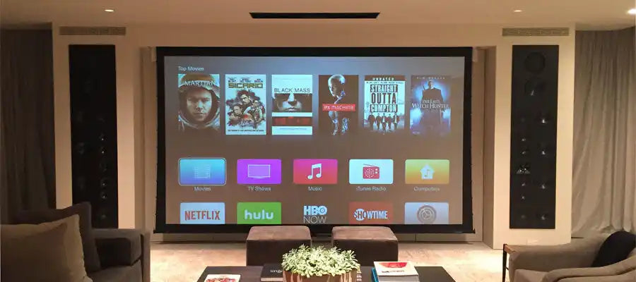 Home theater setup with a large screen displaying an Apple TV interface.